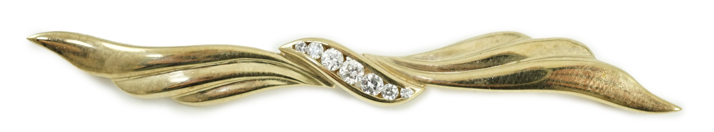 A modern 9ct gold and graduated seven stone diamond set wavy bar brooch, 68mm, gross weight 5.3 grams.
